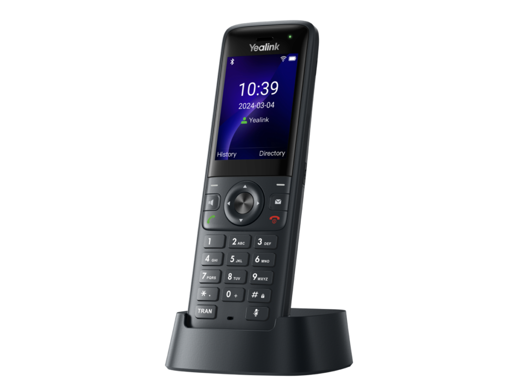 A black Yealink cordless phone stands upright in its charging dock. The display screen shows the time 10:39, the date 2024-03-04, and menu options for History and Directory.