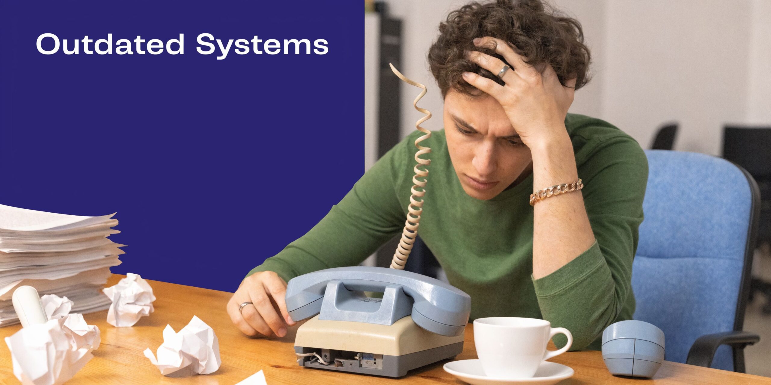 A stressed office worker sitting at a desk with an old telephone, piles of paper, and crumpled notes.