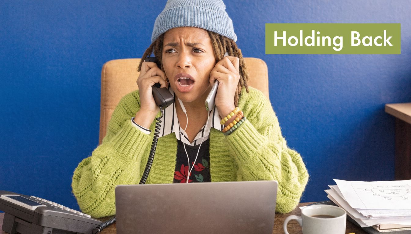 A woman wearing a beanie and green sweater looks stressed while multitasking on two phones.