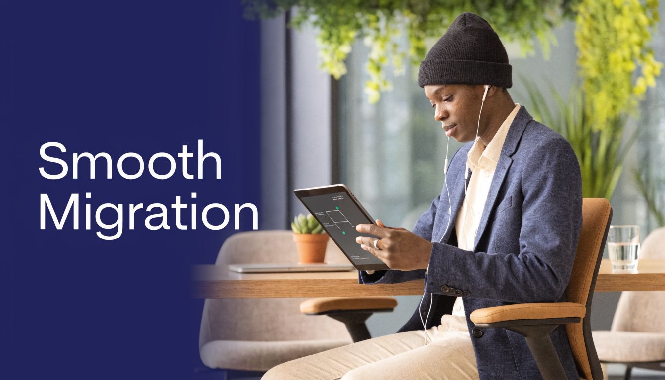 A young professional wearing a beanie and suit jacket working on a tablet in a modern office.