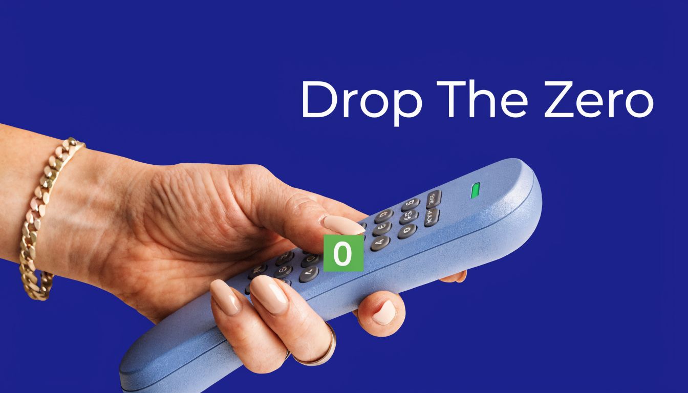 A hand holding a blue remote control with a green square displaying the number zero