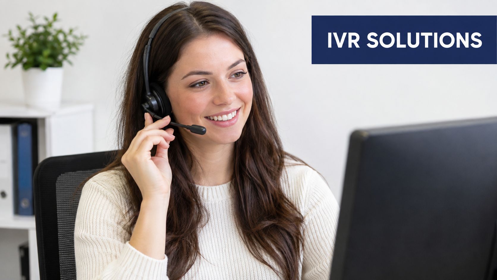 A friendly customer service representative wearing a headset and smiling while working at her computer workstation.