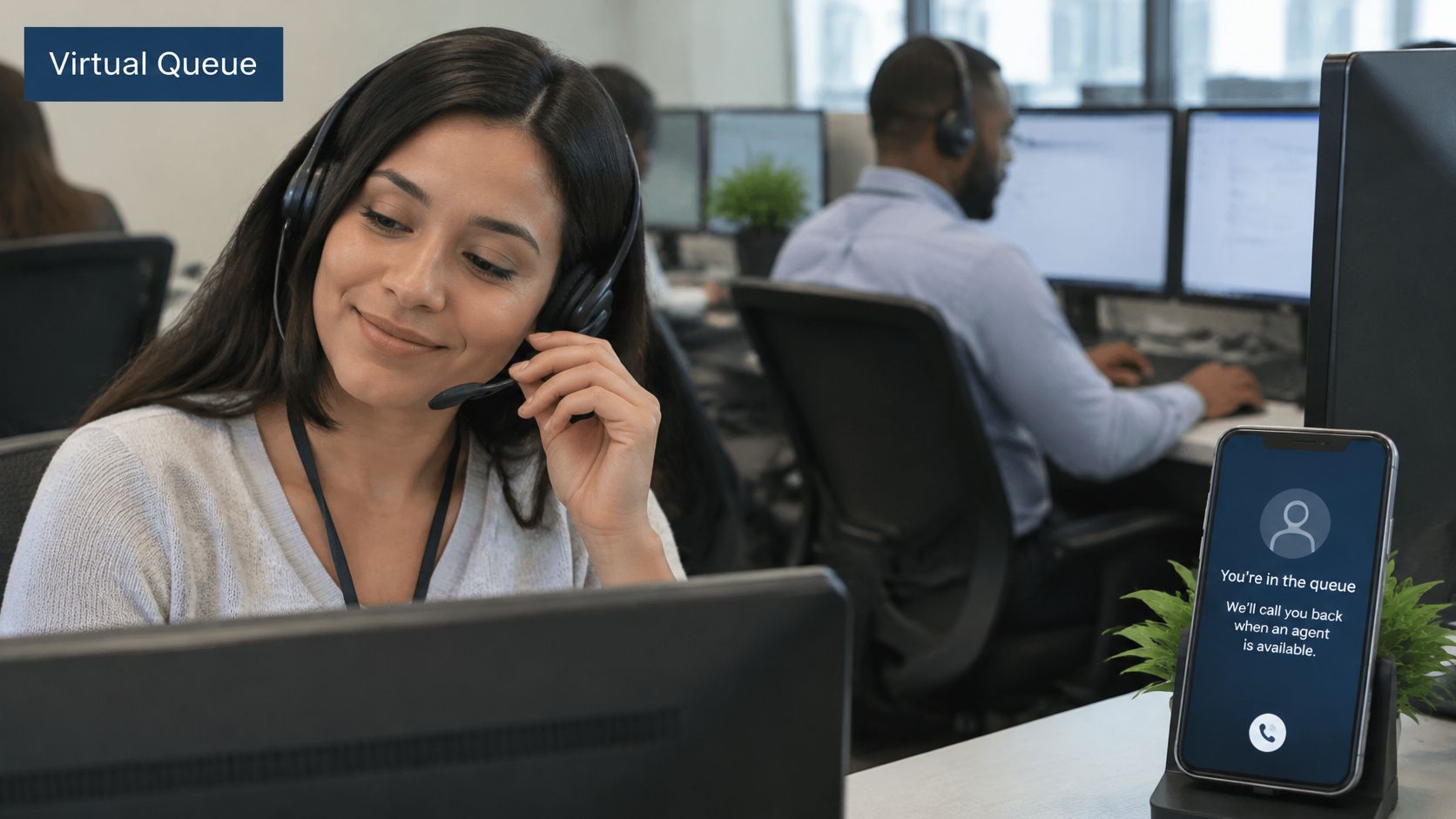 A friendly customer service agent wearing a headset working in an office with virtual queue software displayed.